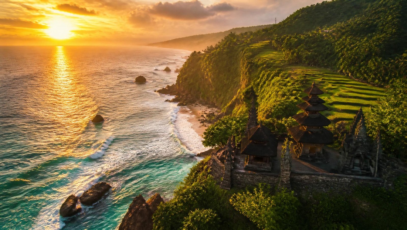 Aerial view of a Balinese cliff temple above a turquoise ocean at sunset